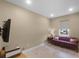 Bedroom featuring wood-look flooring, a window with blinds, and a red striped sofa with decorative pillows at 1020 Taproot Dr, Winter Springs, FL 32708