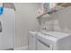 Functional laundry room features a side-by-side washer and dryer with white cabinets and shelving for storage at 1020 Taproot Dr, Winter Springs, FL 32708