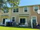 View of the townhome's backyard featuring a sliding door, grill, garbage cans, and green grass at 11187 Savannah Landing Cir, Orlando, FL 32832