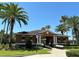 Community building featuring a welcoming entryway, seating, palm trees, and well-maintained landscaping at 11187 Savannah Landing Cir, Orlando, FL 32832