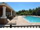 Community pool featuring a spacious deck with lounge chairs, and a covered patio area for relaxation at 11187 Savannah Landing Cir, Orlando, FL 32832