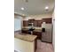 Modern kitchen featuring stainless steel appliances, granite countertops, breakfast bar, and wood cabinets at 11187 Savannah Landing Cir, Orlando, FL 32832