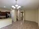 Spacious living room boasts tile floors, a modern chandelier, and views of the kitchen and staircase at 11187 Savannah Landing Cir, Orlando, FL 32832