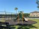 Community playground featuring a slide, climbing area, basketball court, and scenic lake views at 11187 Savannah Landing Cir, Orlando, FL 32832