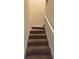 Carpeted stairs with white railing leading upstairs, showcasing the neutral color palette of the home at 11187 Savannah Landing Cir, Orlando, FL 32832