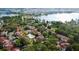 A scenic aerial view captures a lakeside community with multiple buildings, a pool, and a tennis court amidst lush greenery at 11568 Westwood Blvd # 1015, Orlando, FL 32821