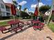 Common picnic area featuring multiple red metal picnic tables with umbrellas near the community buildings at 11568 Westwood Blvd # 1015, Orlando, FL 32821
