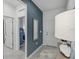 Modern entryway with a blue accent wall, stylish mirror, and neutral tile flooring at 1219 Normandy Dr, Haines City, FL 33844