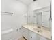 Bright bathroom featuring a marble countertop, white cabinets, large mirror, and neutral tile flooring at 1404 Oak Pl # A, Apopka, FL 32712