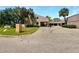 Exterior view of townhome featuring lush landscaping, palm trees, and covered parking at 1404 Oak Pl # A, Apopka, FL 32712