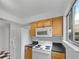 Functional kitchen with white appliances, wood cabinets, and a bright window at 1404 Oak Pl # A, Apopka, FL 32712