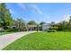 Inviting one-story home featuring a well-manicured lawn, mature trees, and a long driveway at 1770 Chinook Trl, Maitland, FL 32751