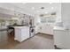 Open kitchen with modern appliances, island, white cabinets, and seamless flow to living area at 1770 Chinook Trl, Maitland, FL 32751