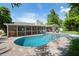 Sparkling in-ground pool with brick paver deck, screened in lanai, and lush tropical landscaping at 1770 Chinook Trl, Maitland, FL 32751