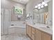 Bathroom features a double sink vanity, a tub, a walk-in shower, and tile floors at 1907 Sir Lancelot Cir, St Cloud, FL 34772