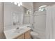 Bright bathroom featuring a shower-tub combo, light wood vanity, and a large mirror reflecting a door to the outside at 1907 Sir Lancelot Cir, St Cloud, FL 34772