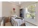 Cozy bedroom with a ceiling fan, one bed, dark wood cabinet, neutral walls, and a large window with plantation blinds at 1907 Sir Lancelot Cir, St Cloud, FL 34772