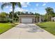 Inviting home with a lush green lawn, mature landscaping, and an expansive driveway at 1907 Sir Lancelot Cir, St Cloud, FL 34772