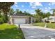 Home exterior featuring a well-maintained lawn, mature landscaping, and a side-entry garage at 1907 Sir Lancelot Cir, St Cloud, FL 34772