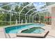 Beautiful outdoor pool area featuring a screened enclosure, a hot tub, patio furniture, and statues at 1907 Sir Lancelot Cir, St Cloud, FL 34772