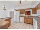 Functional kitchen with wood cabinets and white appliances with dining area at 2003 Bentwood Dr, Winter Park, FL 32792
