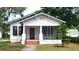 Traditional white home featuring a screened-in porch, brick steps and mature landscaping at 206 N Highland Ave, Winter Garden, FL 34787