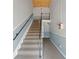 A carpeted stairway features a black railing and a half wall with wainscoting, leading to the upper level at 225 Lewfield Cir # 225, Winter Park, FL 32792