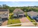 Aerial view of a well-maintained home with a brick driveway, lush lawn, and a three-car garage at 2340 Standing Rock Cir, Oakland, FL 34787
