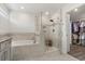 Elegant bathroom showcasing a soaking tub, glass shower, and access to a walk-in closet at 2340 Standing Rock Cir, Oakland, FL 34787