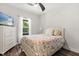 Comfortable bedroom with ceiling fan, a full-sized bed, and a large window overlooking the backyard at 2340 Standing Rock Cir, Oakland, FL 34787