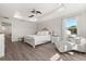 Bright bedroom with tray ceilings, ceiling fan, and comfortable sitting area near a window at 2340 Standing Rock Cir, Oakland, FL 34787