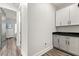 Bright hallway featuring white cabinets, a black countertop, and an adjacent doorway at 2340 Standing Rock Cir, Oakland, FL 34787