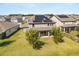 Back exterior showcasing the home's solar panels, well-maintained lawn, and rear patio at 2340 Standing Rock Cir, Oakland, FL 34787