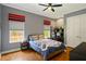 Comfortable bedroom with hardwood floors, large windows, ceiling fan, and desk and chair setup at 2357 Alaqua Dr, Longwood, FL 32779