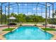 Enclosed in-ground pool with ample seating, landscaping, and brick patio at 2357 Alaqua Dr, Longwood, FL 32779