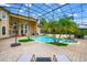 Exterior shot of the home featuring an enclosed in-ground pool, manicured landscaping, and brick patio at 2357 Alaqua Dr, Longwood, FL 32779
