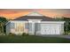 Charming single-story home featuring a three-car garage and well-manicured lawn at sunset at 2609 Clear Night Ave, Kissimmee, FL 34744