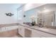 Bathroom featuring double sinks, soaking tub, large mirror and shower with glass door at 3004 Protagonist St, Kissimmee, FL 34746