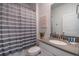 Bright bathroom featuring a shower with gray and white striped curtain and gray countertops at 3004 Protagonist St, Kissimmee, FL 34746