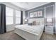 Bedroom features a comfortable bed, stylish wall art, and two large windows at 3004 Protagonist St, Kissimmee, FL 34746