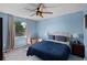 Well-lit bedroom featuring a large window, fan, and comfortable bedding at 3028 Parkway Blvd # 308, Kissimmee, FL 34747