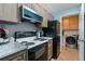 Well-lit kitchen features stainless steel appliances, light wood cabinetry, and granite countertops at 3028 Parkway Blvd # 308, Kissimmee, FL 34747