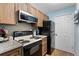 Efficient kitchen with wooden cabinets, black appliances, and sleek countertops at 3028 Parkway Blvd # 308, Kissimmee, FL 34747