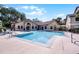 Community pool area with a shallow end, lounge chairs and a clubhouse with red doors at 3028 Parkway Blvd # 308, Kissimmee, FL 34747