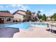 Community pool with lounge chairs, manicured landscaping, and a building in the background at 3028 Parkway Blvd # 308, Kissimmee, FL 34747