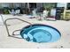 Community spa with steps and seating surrounded by lounge furniture and spa rules sign at 3028 Parkway Blvd # 308, Kissimmee, FL 34747