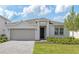 Charming one-story home with a two car garage and welcoming landscaped front yard at 3088 Windswept, Wildwood, FL 34785