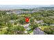 Scenic aerial view of a home in a lush, community neighborhood with a waterfront backdrop at 310 E Gulley Ave, Oakland, FL 34760