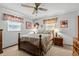 Bedroom with neutral carpet, ceiling fan, bed, floral accents and traditional style decor at 310 E Gulley Ave, Oakland, FL 34760