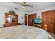 Bedroom with ceiling fan, tv, dresser with mirror, and closet with louvered doors at 310 E Gulley Ave, Oakland, FL 34760